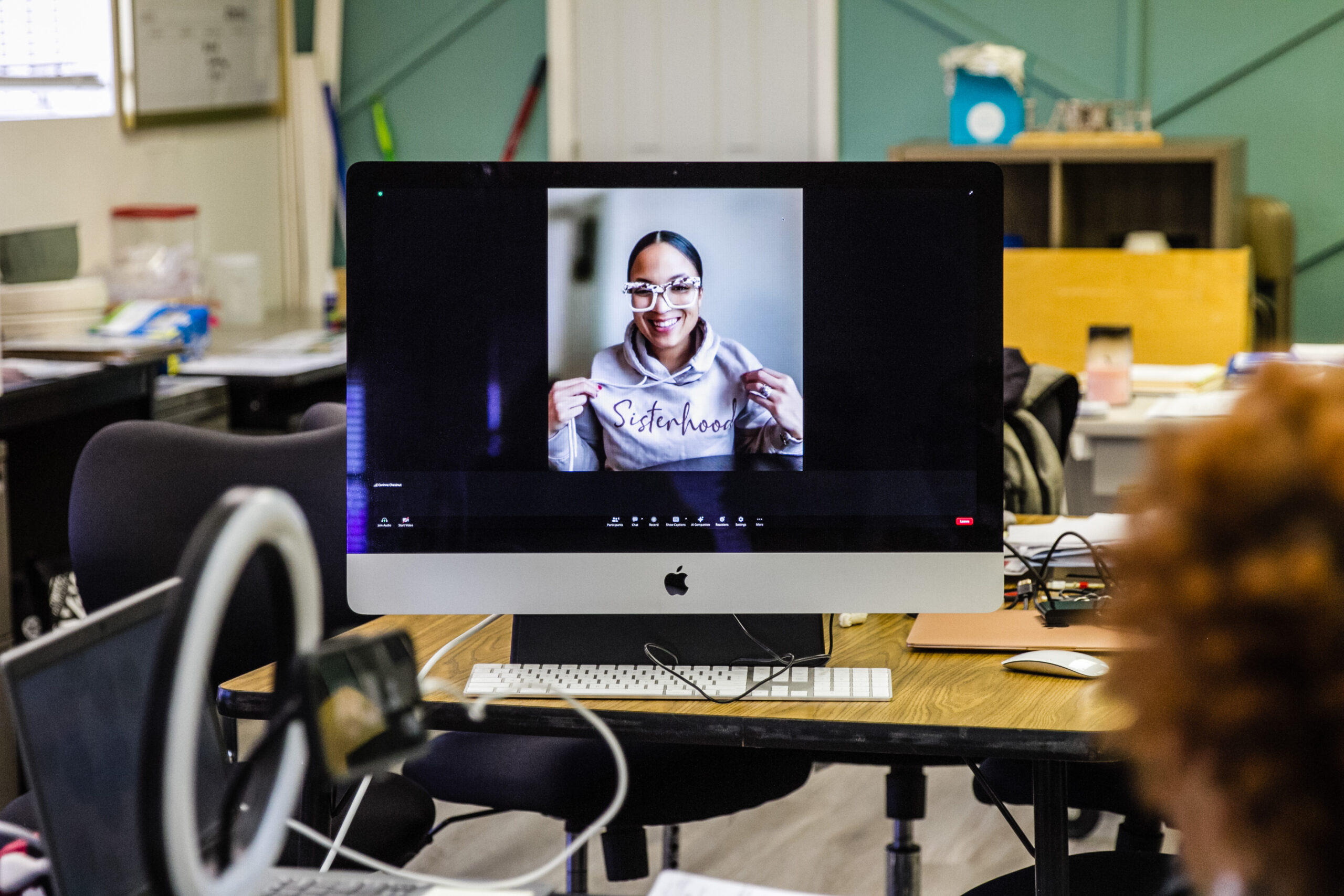 woman on virtual meeting with "sisterhood" sweatshirt