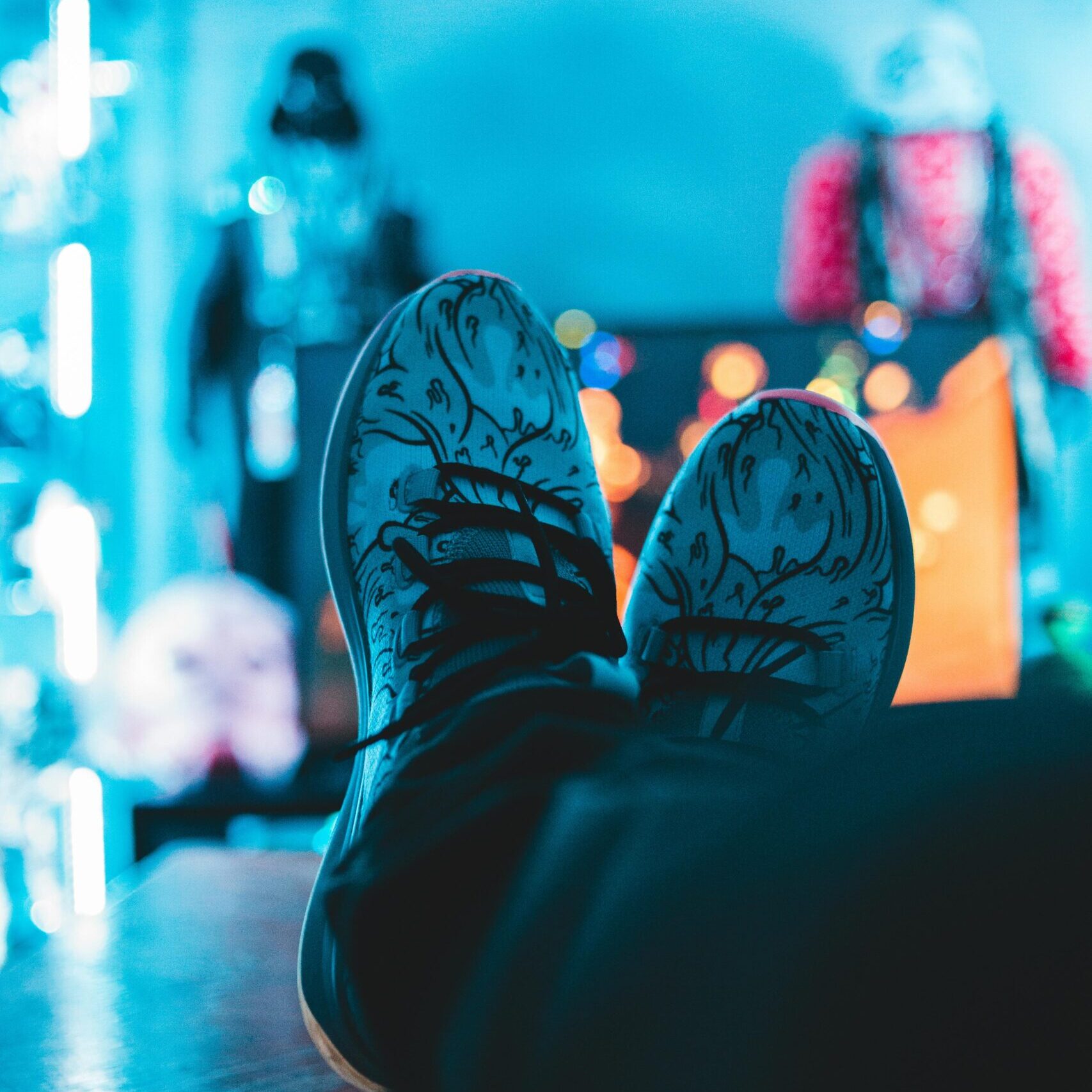 sneakers resting on top of a table with neon, party scene in background