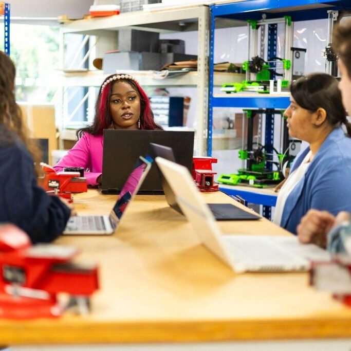 Group of people around a table with laptops